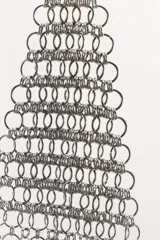 Top plateado de anillas metálicas con cuello halter y hombros descubiertos. Se cierra con mosquetón en cuello y espalda.