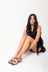 Chatas de cuero con estampado animal print marrón y blanco, con correa sobre el empeine y hebilla metálica.