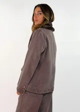 Chaqueta de gabardina color tostado con cuello de piel sintética en tono marrón, cierre frontal con botones y bolsillos delanteros con solapa.