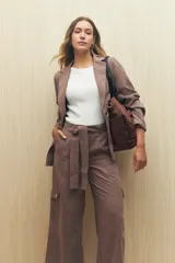 Pantalón de tiro alto color ladrillo, de corte ancho y con cinturón de la misma tela.