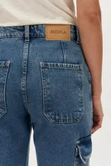 Pantalón cargo de denim en tono azul medio, de tiro alto y corte recto, con bolsillos laterales con solapa.