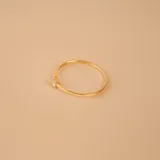 Anillo de oro 18k compuesto por una alianza fina con un brillante engastado y una estructura entrelazada de diseño moderno.