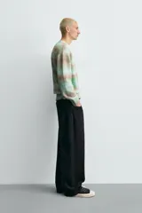 Jersey de punto con ajuste relajado, cuello redondo y manga larga. Presenta un diseño de rayas horizontales difuminadas en tonos verde agua y marrón, con acabados en rib en cuello, puños y ruedo.