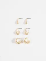 Set de tres pares de aros dorados con diferentes diseños: un par con forma de gota, un par con forma de U pequeña y un par con forma de C.