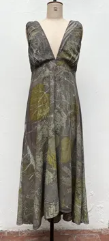 Vestido largo con estampado de hojas en tonos verdes y marrones.