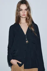 Camisa fluida de viscosa con cuello solapa de muescas, manga larga con puños y bolsillo de plastrón en el pecho. Cierre frontal con botones.