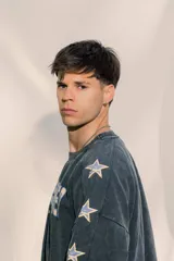 Crewneck de manga larga color gris oscuro con efecto lavado, estampado frontal con el texto "ENDLESS SUMMER" y estrellas estampadas a lo largo de las mangas.