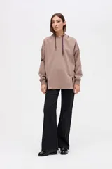 Canguro oversize de felpa con friza, color marrón. Presenta capucha forrada con cordones ajustables, cortes en el cuerpo y tajos decorativos en el frente.