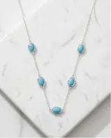 Collar de cadena fina de plata con cinco piedras ovaladas de color turquesa engarzadas a lo largo de la pieza.