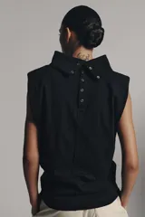 Top negro de hilatura de algodón, sin mangas y con cuello subido. Cuenta con cierre en la espalda mediante botones a presión.