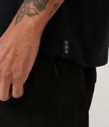 Musculosa básica para hombre de corte recto y cuello redondo, confeccionada en tejido de algodón. Presenta un diseño liso con un pequeño tag decorativo en el bajo.