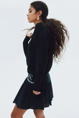 Buzo negro de punto fino suave con hombros descubiertos y escote enrollado. Modelo de manga larga con hombros caídos y remate acanalado en puños y bajo.