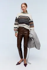 Sweater de lana merino color crudo con diseño geométrico, cuello redondo con detalle de color verde y lentejuelas delicadas.