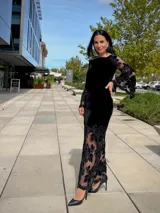 Falda larga de terciopelo negro con diseño ajustado en la parte superior y ruedo con transparencias de encaje floral y red.