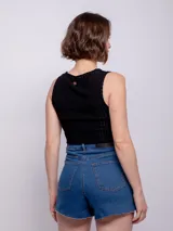 Short de jean negro con cuatro bolsillos, presillas, terminación desflecada, botón y cierre metálico.