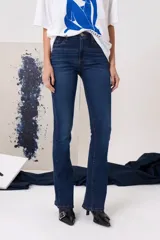 Jean de tiro medio con corte oxford, confeccionado en denim azul oscuro con costuras a contratono. Presenta cierre frontal con botón metálico, bolsillos delanteros y traseros.