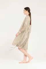 Vestido camisero de cuello mao y corte amplio, confeccionado en popelina de viscosa con mangas de viscosa y seda, con botones en el frente, jaretas ajustables a los costados y largo a la rodilla.