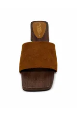 Zueco de inspiración artesanal marca Daniel Cassin, con base efecto madera y taco bajo. Presenta una capellada ancha de color negro con detalles de tachas metálicas doradas en los laterales.