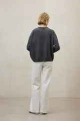 Suéter de punto liso, color gris oscuro, con cuello redondo y calce holgado.