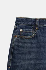 Jeans de tiro medio y corte relaxed fit, color azul con efecto deslavado, diseño de cinco bolsillos y bajo vuelto. Cuenta con cierre frontal de cremallera y botón metálico.