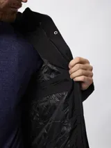 Campera de nylon acolchada en color azul marino, con cierre frontal y botones a presión, bolsillos laterales y capucha desmontable.
