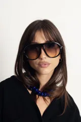 Lentes de sol estilo aviador con armazón negro y cristales degradados en tono marrón. Cuentan con protección UV400 y están fabricados en policarbonato.