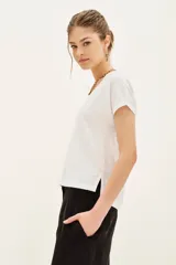 Remera blanca de algodón con cuello en V y mangas cortas.