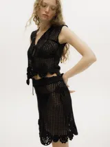 Top negro de algodón tejido al crochet, con diseño calado, apliques florales y tirantes finos.