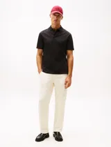 Chomba negra de manga corta con cuello clásico y tapeta de dos botones. Presenta un patrón integral con el logo de la marca y el logo bordado en la manga. Confeccionada en algodón BCI y elastolefín.