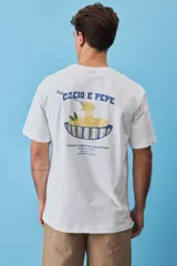 Remera blanca de algodón, de corte holgado y mangas cortas, con pequeño estampado azul en el pecho.