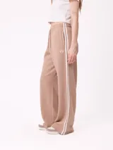 Pantalon de jogging de corte ancho, color negro con rayas laterales blancas. Posee cintura elastizada con cordón de ajuste y logo bordado en la parte frontal.