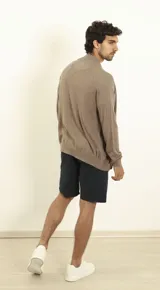 Cardigan azul de tejido de punto con cierre frontal, cuello alto y bolsillos laterales.