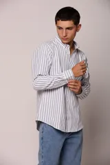 Camisa de manga larga con estampado de rayas verticales, cuello abotonado y cierre frontal con botones.