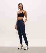 Pantalón deportivo tipo jogger de mujer, con cintura elástica ajustable mediante cordón, bolsillos laterales y puños ajustados en los tobillos. Confeccionado en tejido técnico de poliéster y elastano, ofrece un calce cómodo y holgado ideal para actividades físicas.
