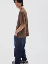 Pantalón tipo cargo confeccionado en tela de brim de algodón color azul marino. Presenta un diseño de calce holgado (baggy) con costuras en contraste de color naranja y bolsillos laterales funcionales.