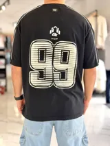 Remera negra de corte regular y manga corta, con costuras decorativas claras en los hombros y mangas, y gran estampado en la espalda con el número '99' y logo superior.