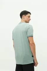 Polo de manga corta color verde agua, con cuello henley y logo bordado en el pecho.