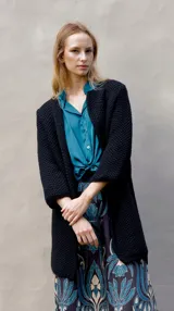 Tapado de punto color negro con textura tipo waffle, corte recto y mangas largas.