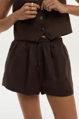 Short de lino color marrón, con cintura elástica con cordón de ajuste y bolsillos laterales.