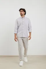 Camisa sport de hombre con cuello button-down, manga larga y diseño a rayas verticales blancas y marrones. Presenta un bolsillo de parche en el pecho y botones de madera.
