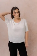 Buzo liviano de punto color blanco, de manga corta, con escote redondo y terminaciones con bordes enrollados.