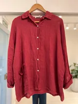 Camisa oversize color bordó, de manga larga con puños doblados, cuello camisero, cierre frontal de botones y un bolsillo aplicado en el frente.