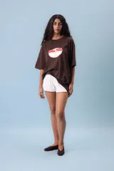 Remera oversize color lila con estampado frontal de un óvalo con la frase "Chill Peel" en marrón.