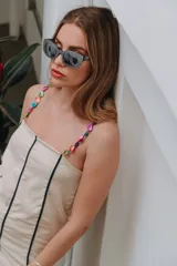 Vestido color crema con tirantes de cuentas de colores, corte recto y largo a la rodilla.