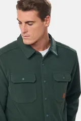 Camisa de manga larga color verde oscuro, de tela polar lisa, con cuello clásico, cierre frontal con botones a presión, dos bolsillos de parche con botón en el pecho y puños abotonados.
