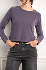 Remera de manga larga color gris malva, con cuello redondo y corte ligeramente cropped.