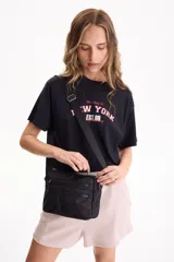 Bandolera negra de nylon con múltiples compartimentos con cierre frontal y correa ajustable para el hombro.