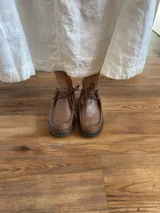 Zapato acordonado de cuero negro con suela de goma.