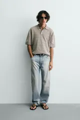 Polo relaxed fit de punto tejido en hilatura con mezcla de algodón y textura rizada, color gris con diseño a rayas sutiles, cuello solapa con cierre frontal de botonadura y manga corta con acabados en rib.