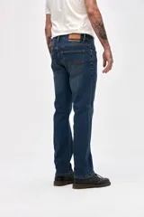 Jean de corte recto clásico con cadera levemente holgada, en tono azul medio con efecto de lavado sutil.